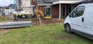 Grondwerk bij nieuwbouw met minigraver en bedrijfsbus