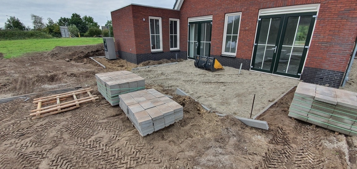 Terras voorbereid, pallets met tegels klaar om te bestraten
