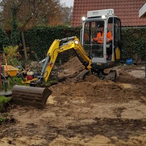 Minigraver aan het werk in een achtertuin