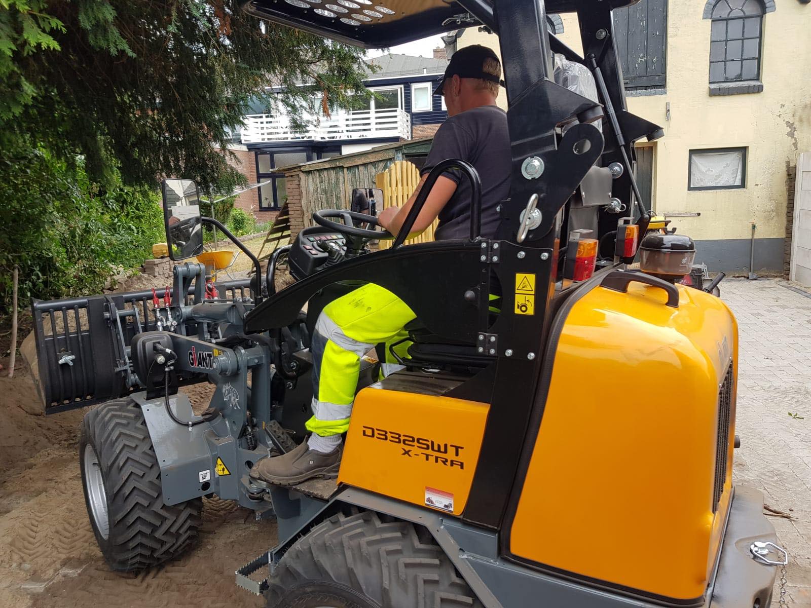 Wiellader verplaatst zand in een tuin